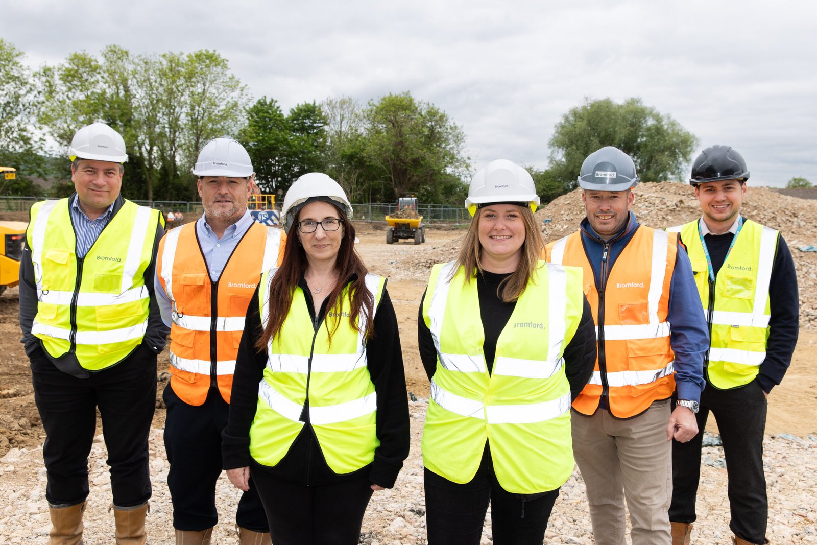 Six Bromford colleagues in high vis jackets and hard hats at its latest development site in Gloucester